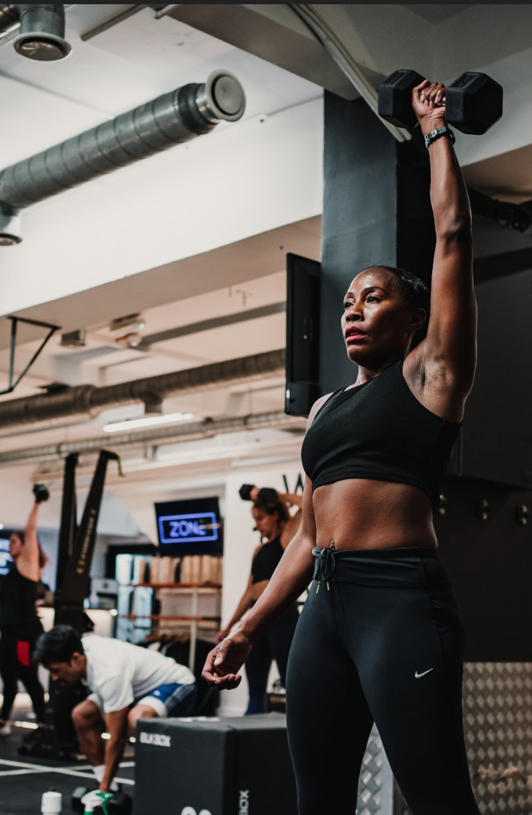 Woman lifting weights at a UN1T gym - Despark