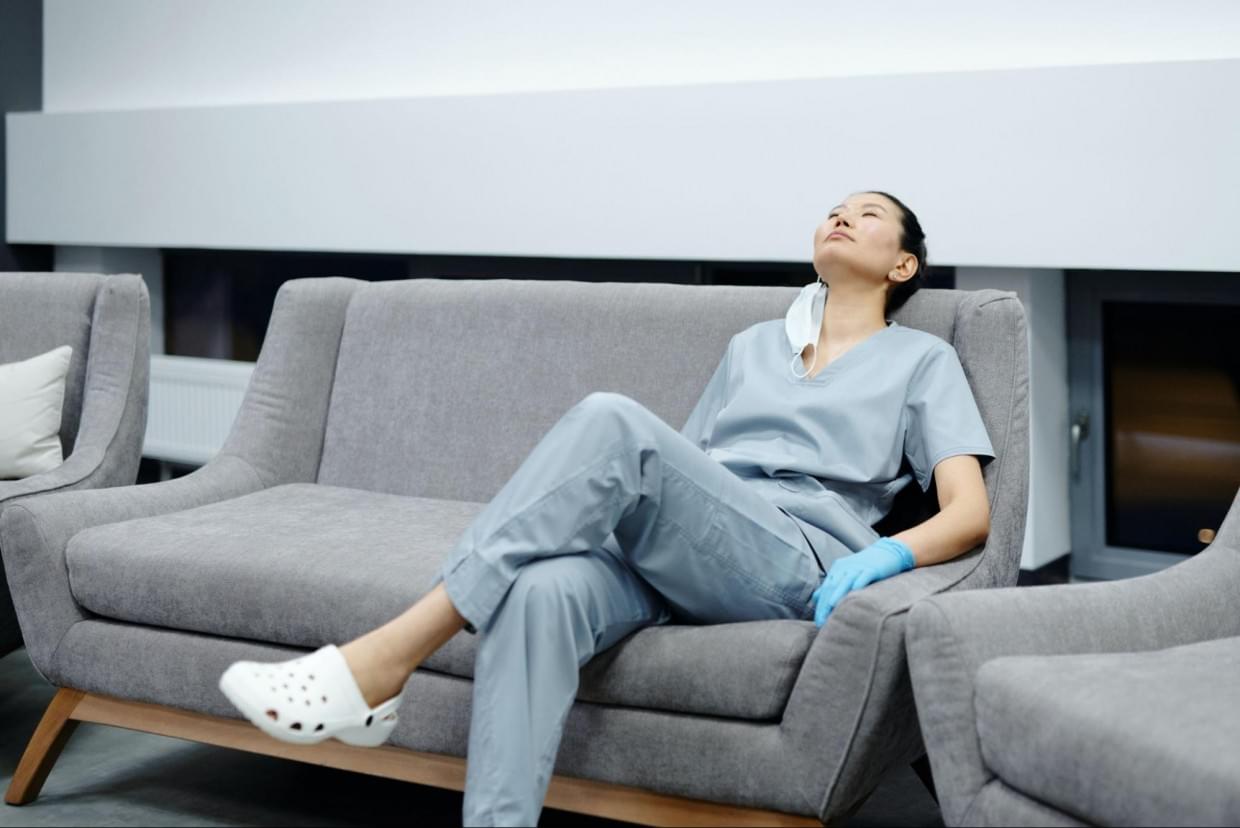 Because of stress, fatigue or sickness, many nurses have taken time off or looked for better employment opportunities. A female nurse resting on a couch in a hospital