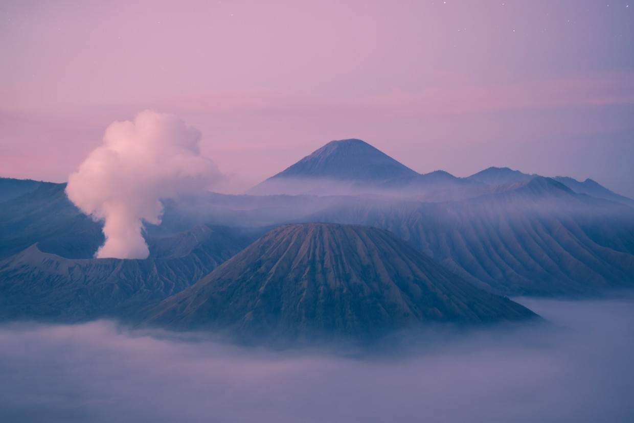 mountains and a volcano in purple tones